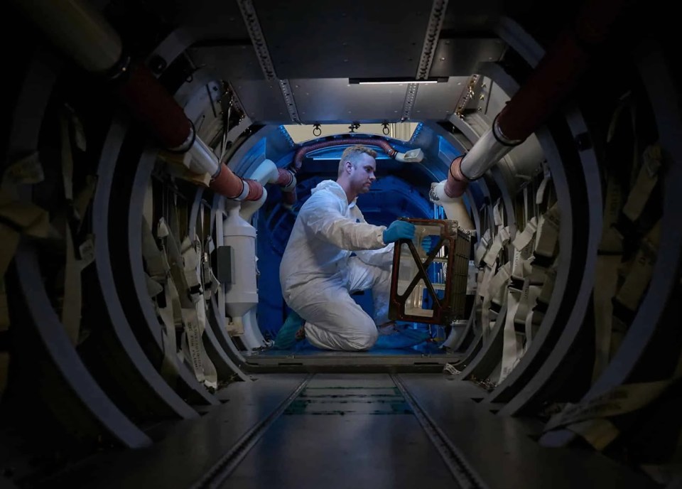 a man in a white suit is working in a tunnel