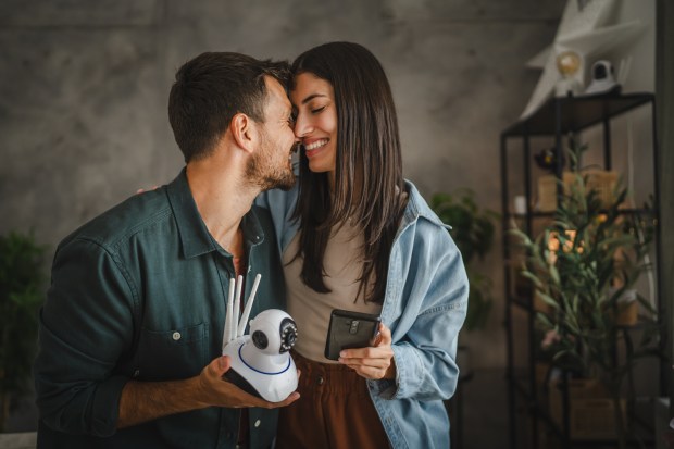 a man kissing a woman while holding a camera