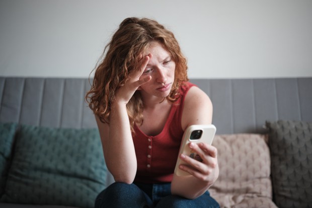 a woman sitting on a couch looking at her phone