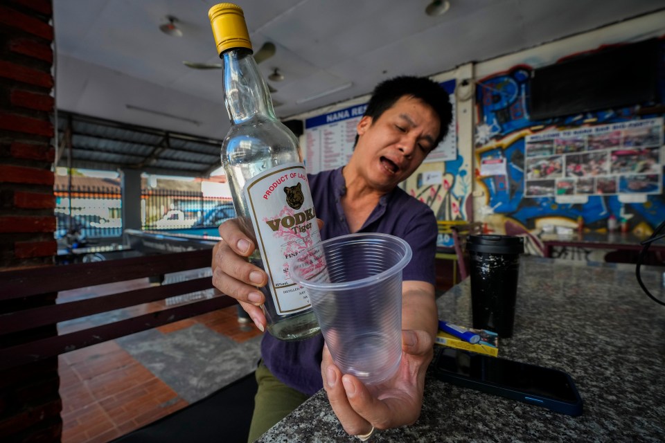 Hostel’s manager Duong Duc Toan shows vodka given away for free