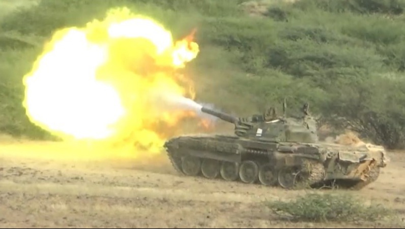 a military tank is firing a cannon in a field