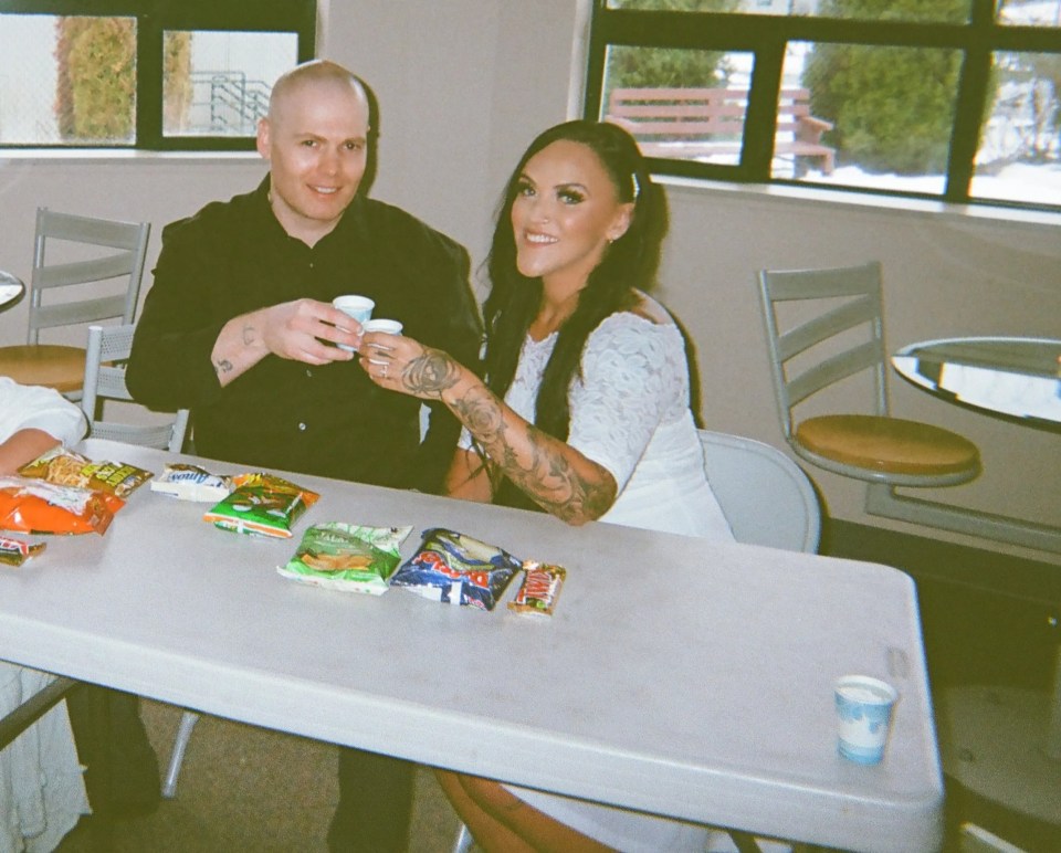 a man and a woman sit at a table with snacks on it