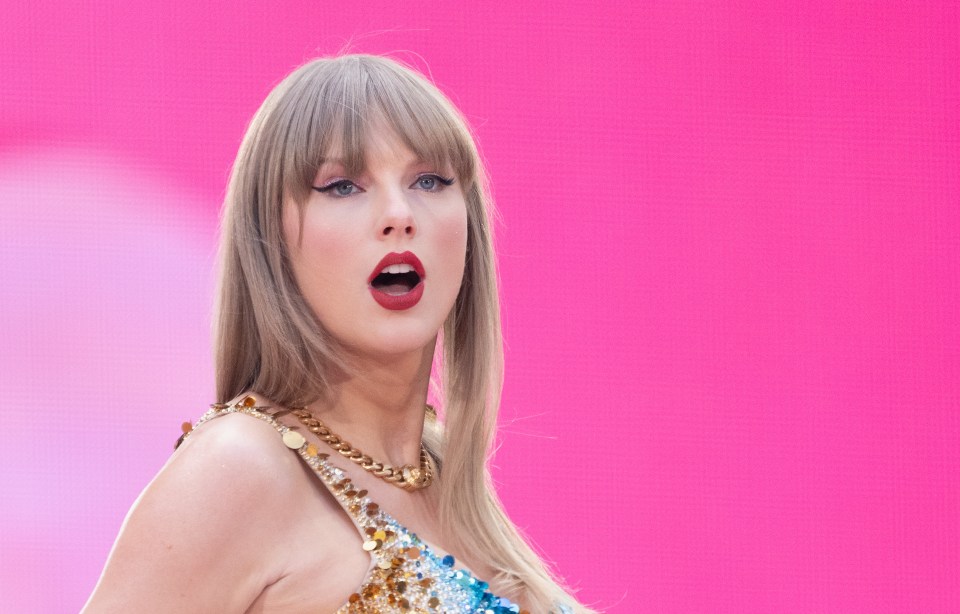 a woman with blonde hair and red lips is standing in front of a pink background