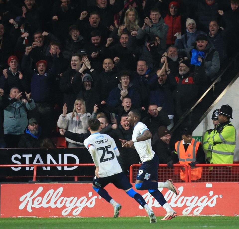 soccer players celebrating a goal in front of a kellogg 's advertisement