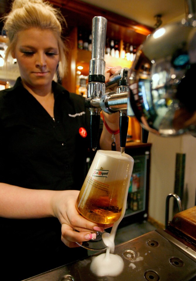 a bartender pours beer from a tap that says san miguel