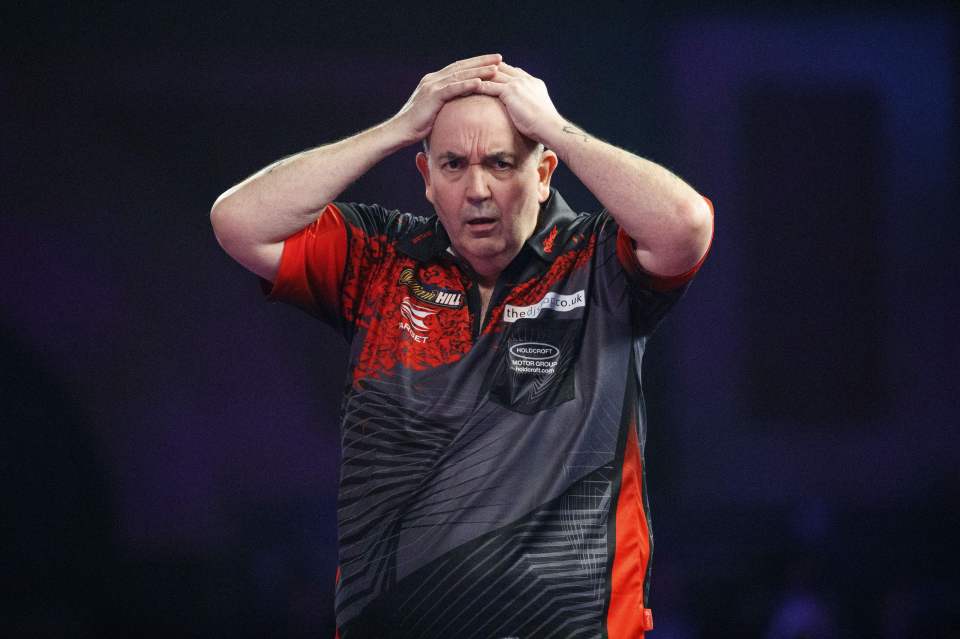 Phil Taylor holds his head in his hands