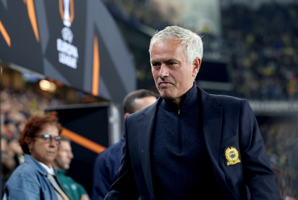 a man in a suit stands in front of a sign that says europa league