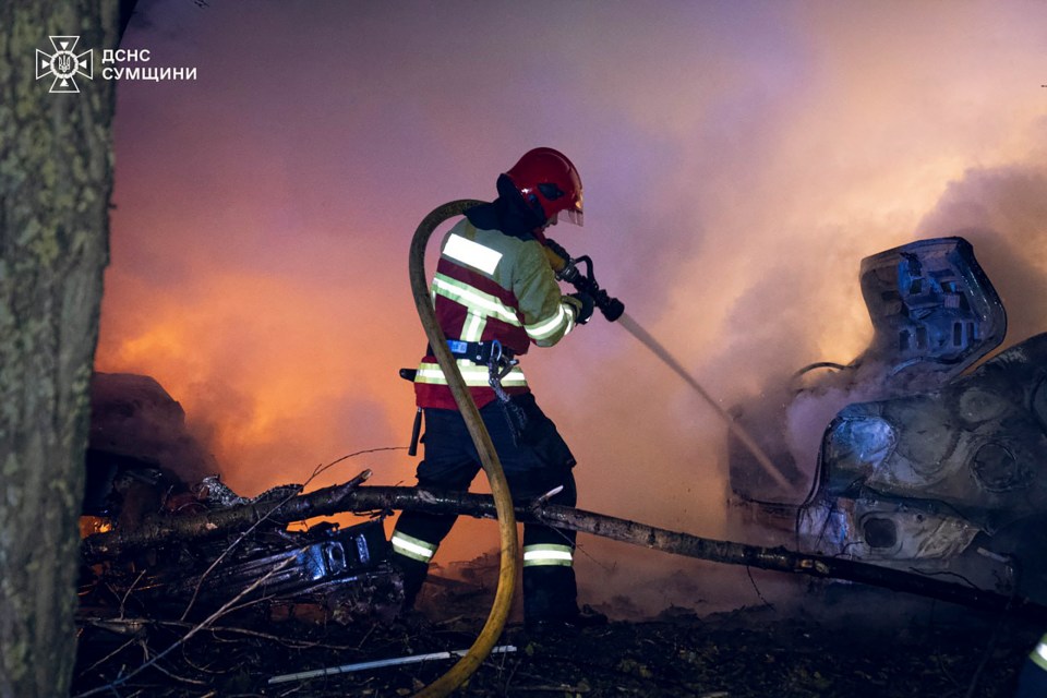 Ukrainian rescuers work at the site of a rocket hit on a residential building in Sumy, Ukraine, where at least 10 people were killed, including two children