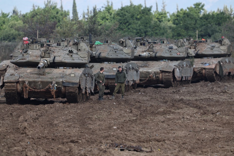 Israeli troops inspecting their tanks parked in a field in northern Israel on Thursday