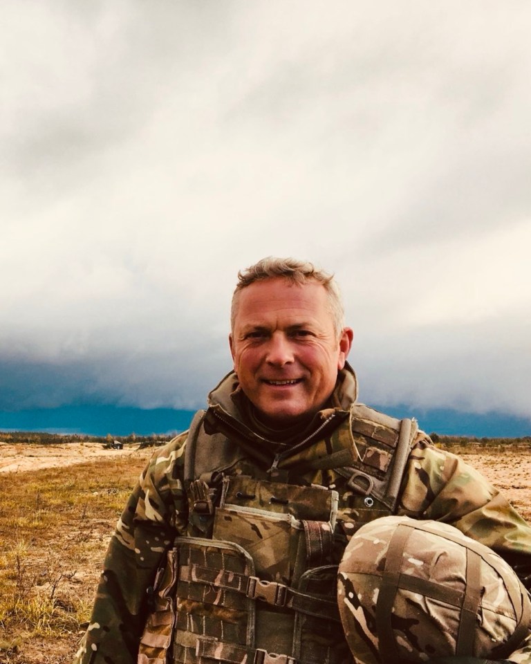 a man in a military uniform stands in a field