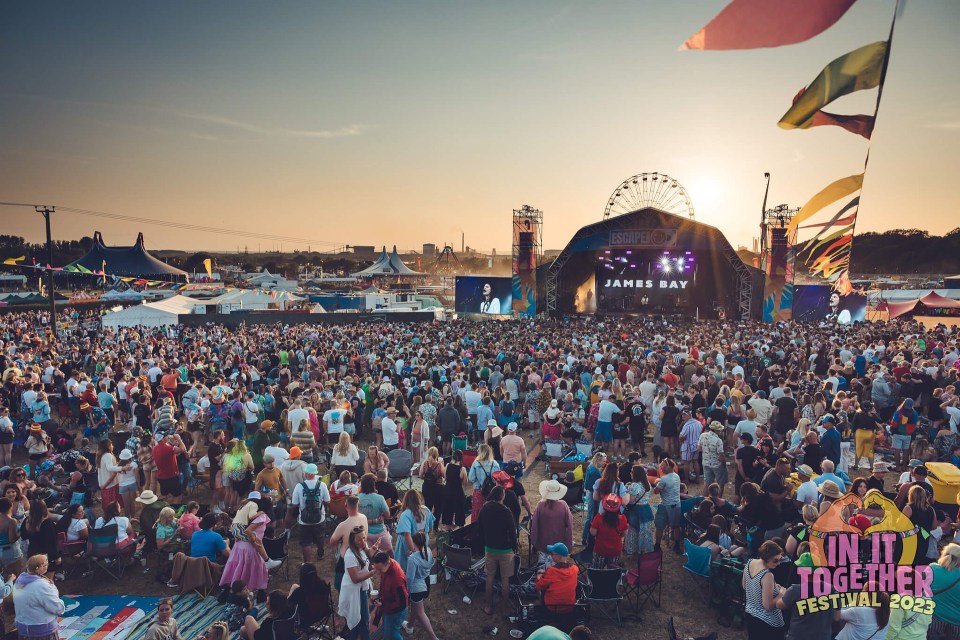 a large crowd of people at a festival with james bay on stage