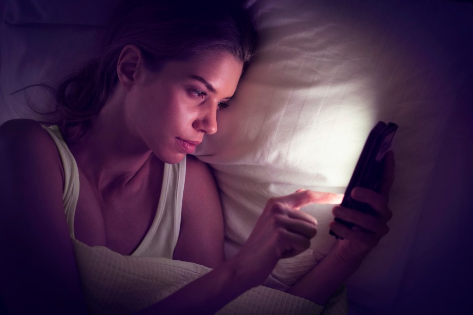 Young woman using digital tablet in bed.