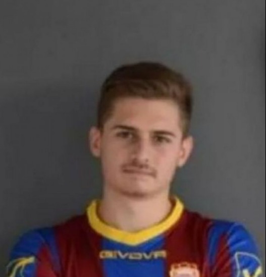 a young man is wearing a soccer jersey and posing for a picture .