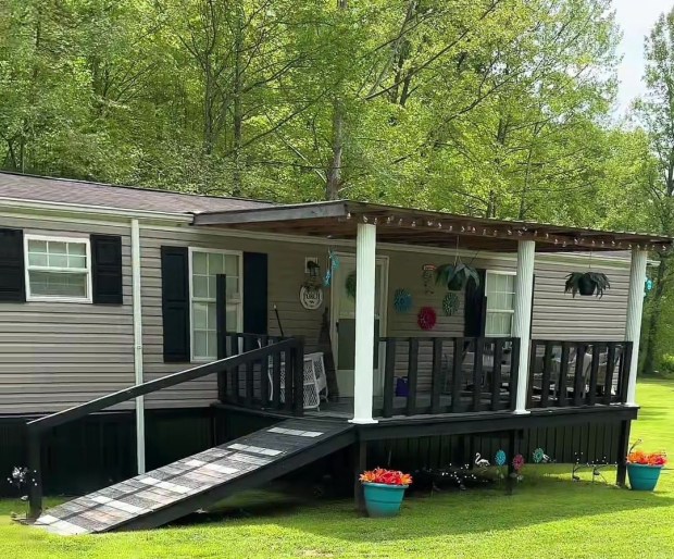 a mobile home with a ramp leading to the porch