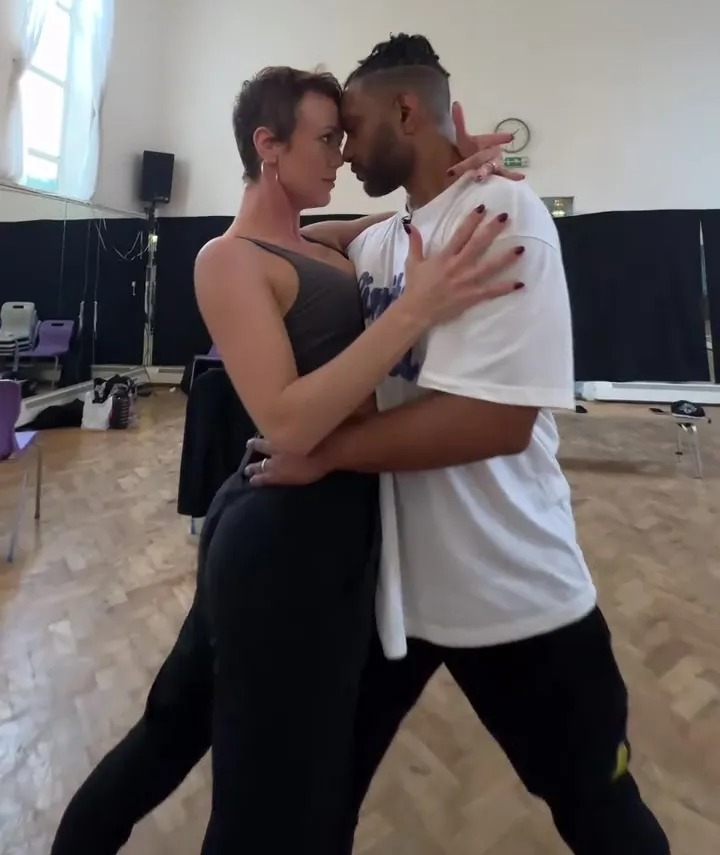 a man and a woman are dancing in a room with a sign that says exit