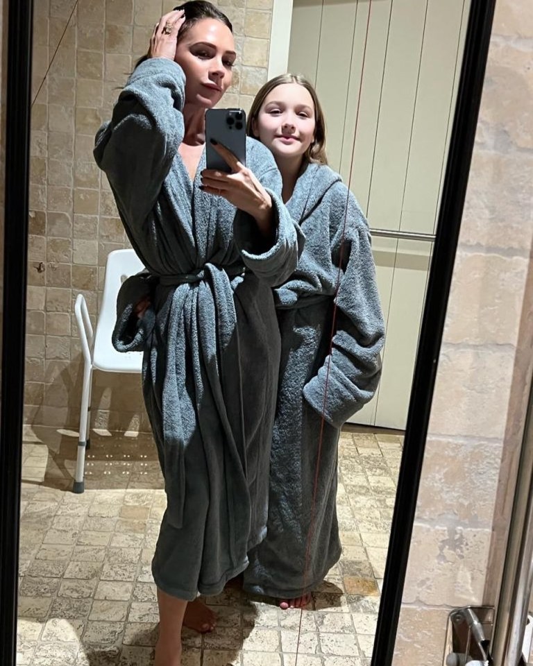 a woman and a girl are taking a selfie in front of a mirror