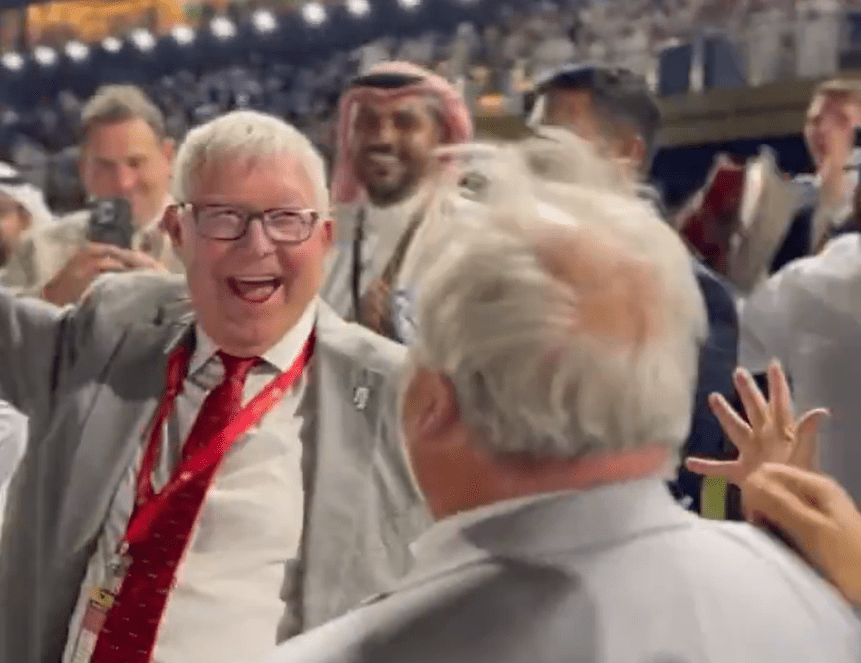 a man in a suit and tie is laughing in a crowd