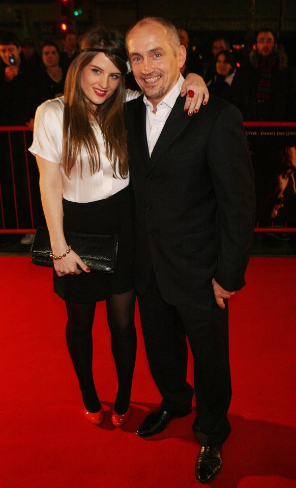 a man and a woman pose for a picture on a red carpet