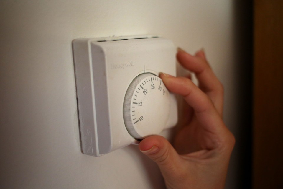 a person is adjusting a honeywell thermostat