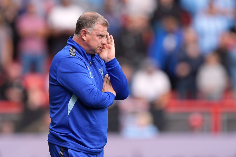 a man in a blue jacket with the word everton on it