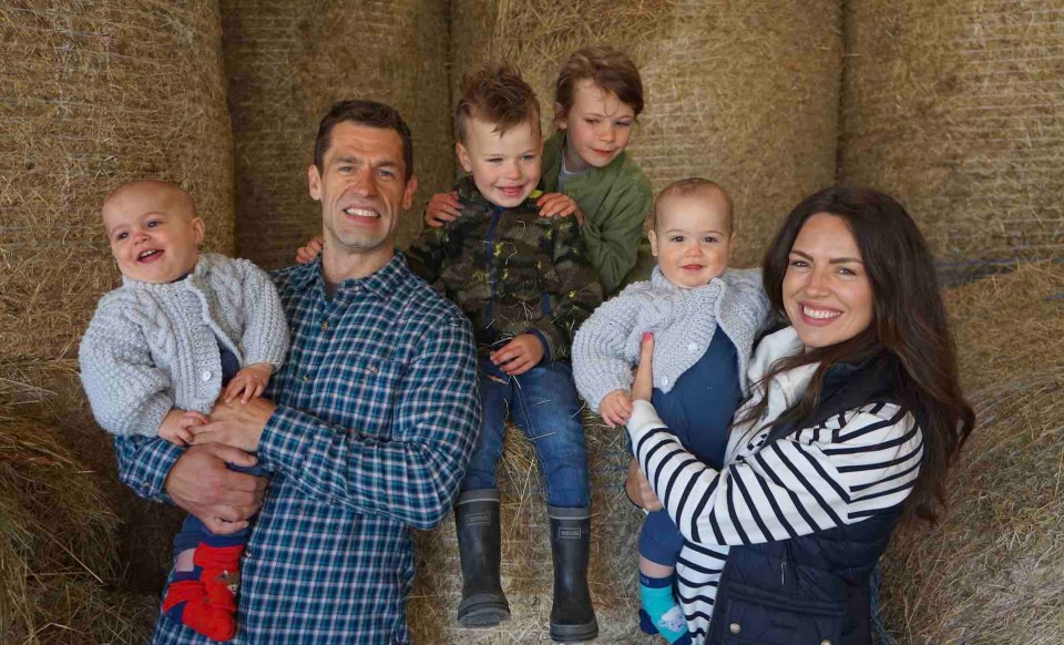 a family posing for a picture in front of hay bales