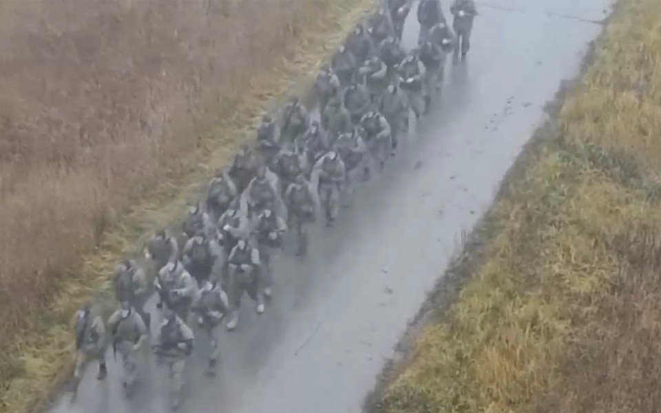 a large group of soldiers are marching down a road