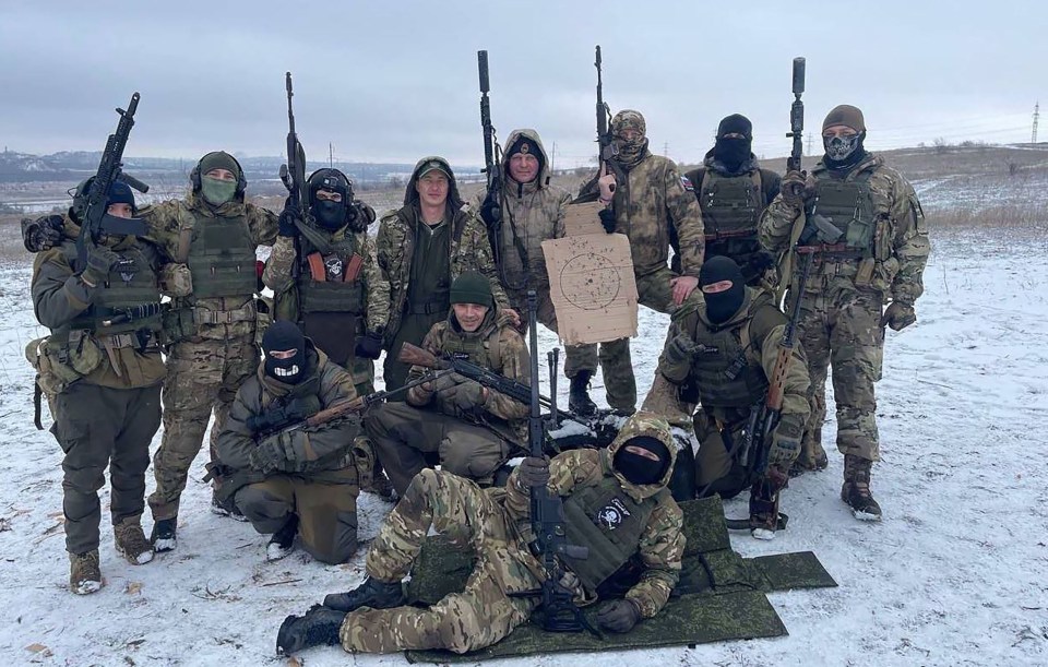 a group of soldiers pose for a photo in the snow