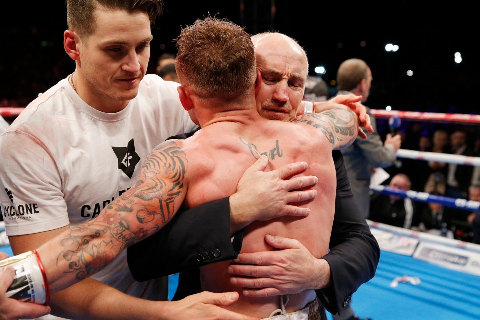 a man hugging another man in a boxing ring with a shirt that says kc one on it