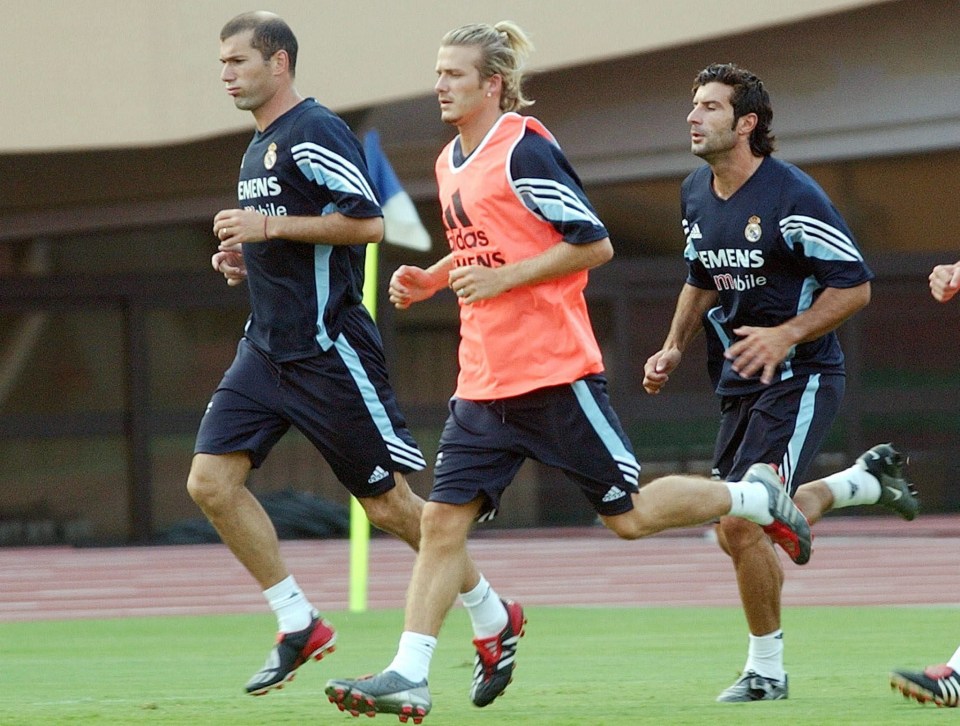 three soccer players are running on a field and one of them is wearing an adidas jersey