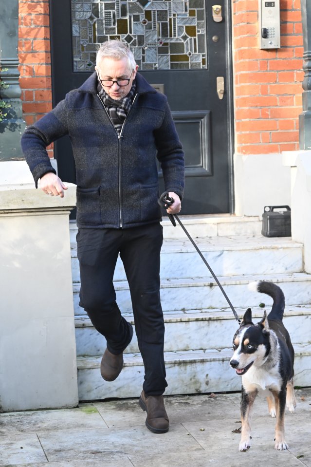 a man walking a dog on a leash in front of a brick building