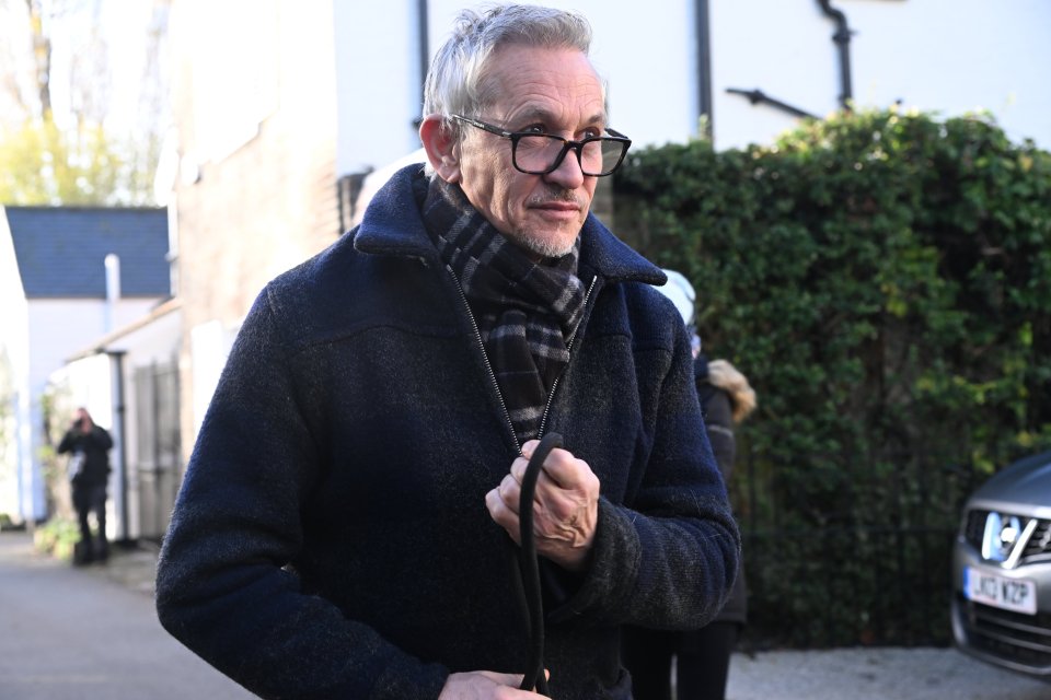 a man wearing glasses and a scarf is walking down a street