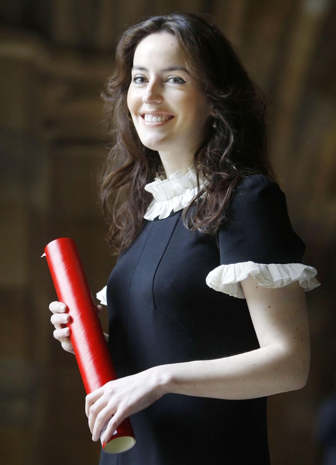 a woman in a black dress is holding a red scroll