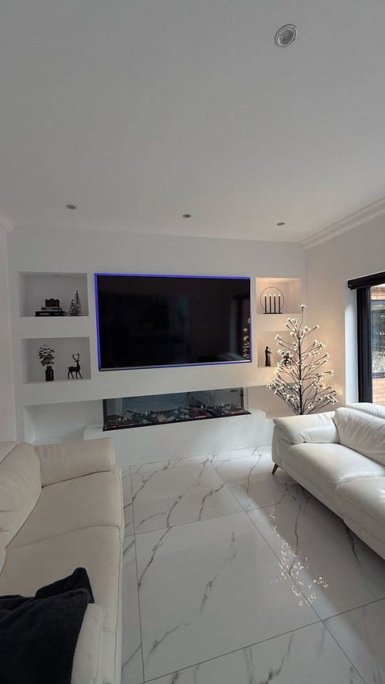 a living room with a christmas tree and a flat screen tv