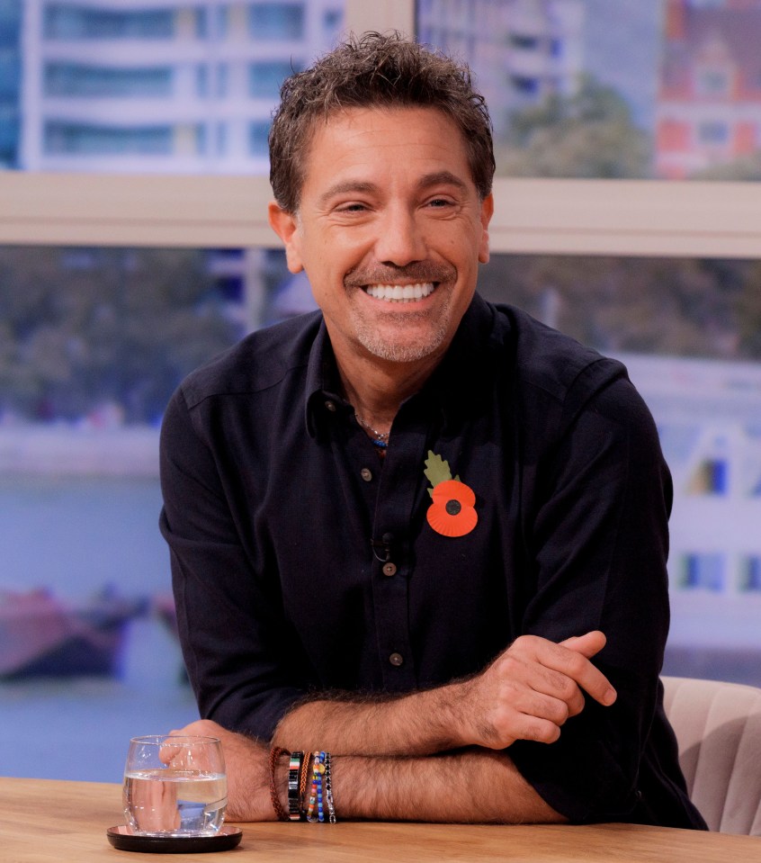 a man wearing a black shirt with a poppy on it