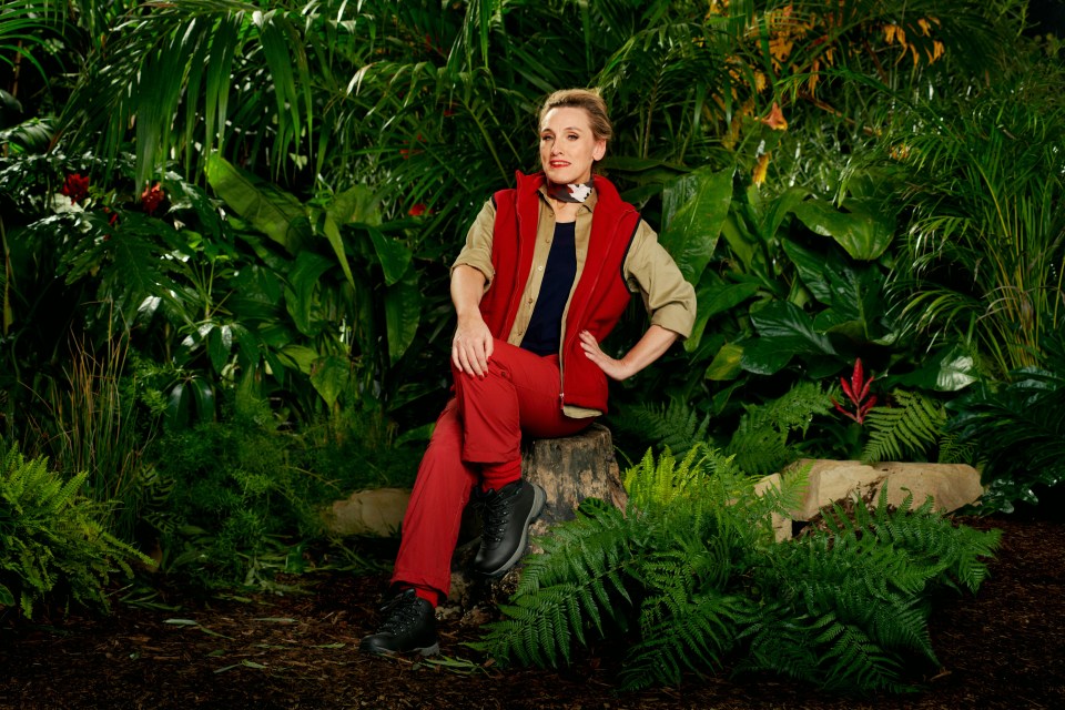 a woman in a red vest sits on a tree stump in the jungle