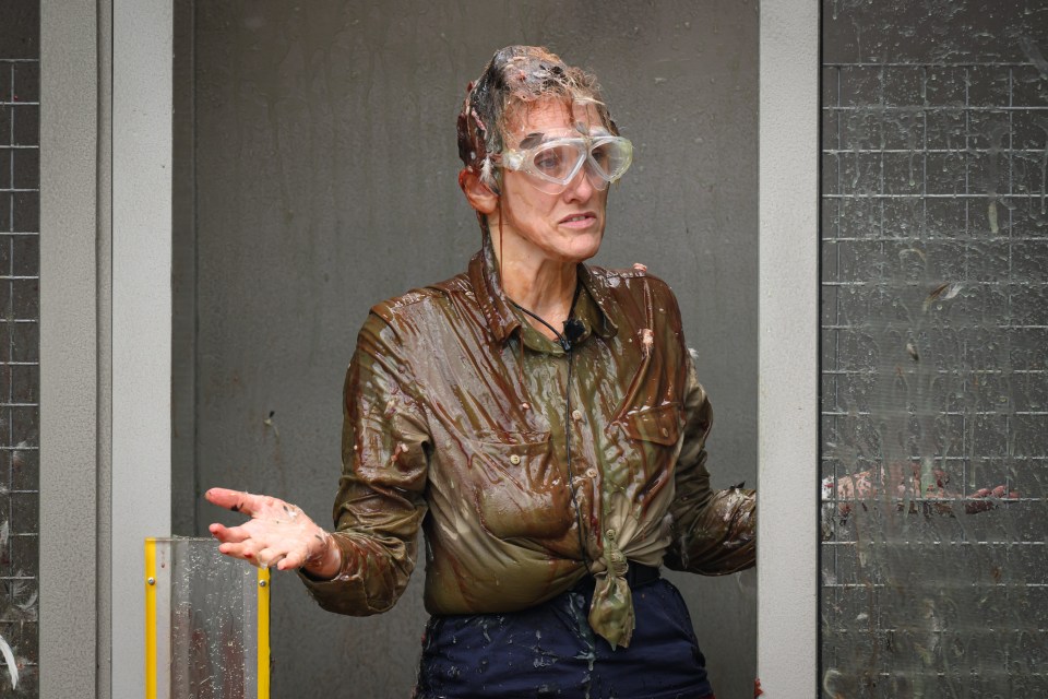 a woman in a wet shirt and goggles is standing in a doorway