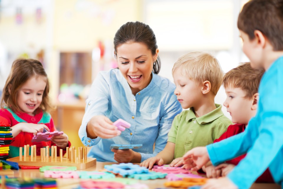 a woman is playing with a group of children