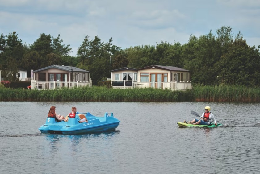 a man in a kayak and a woman in a pedal boat on a lake