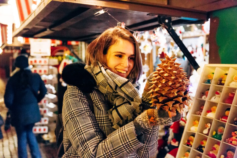 This Christmas market shopper grabs a giant pine cone