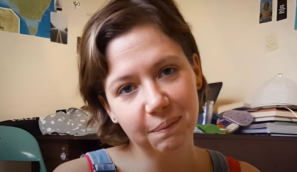 a woman making a funny face in front of a stack of books