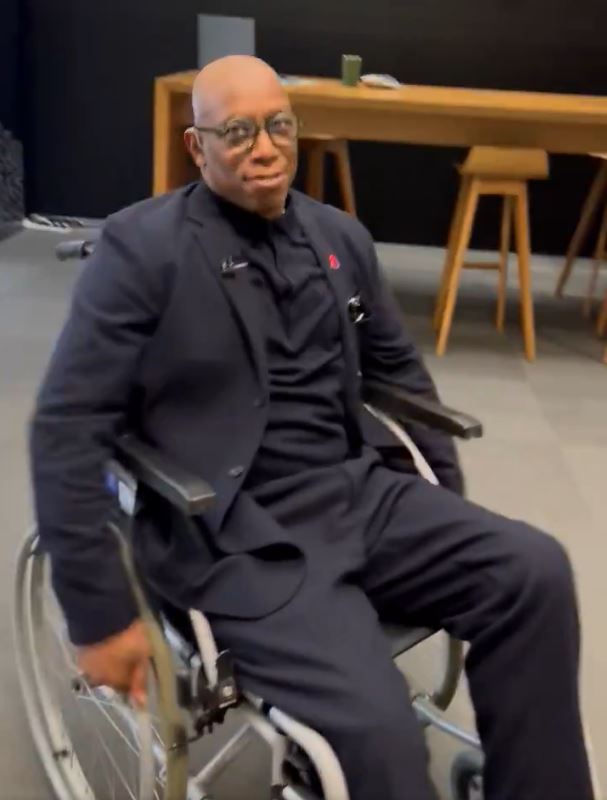 a man in a suit is sitting in a wheelchair .