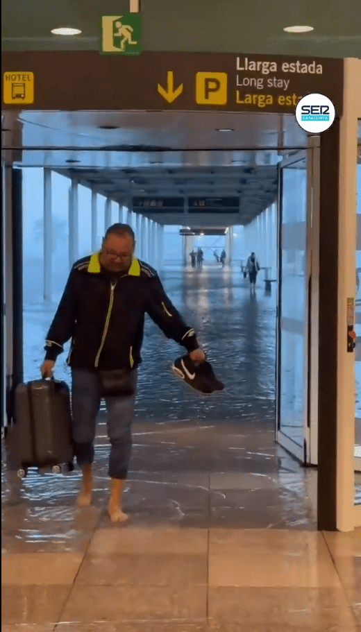 a man walking through a flooded hallway with a sign that says hotel on it