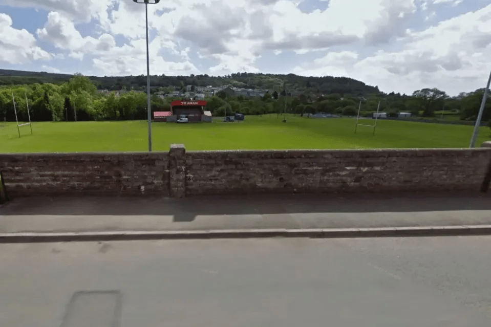 a brick wall surrounds a soccer field with a sign that says st. james