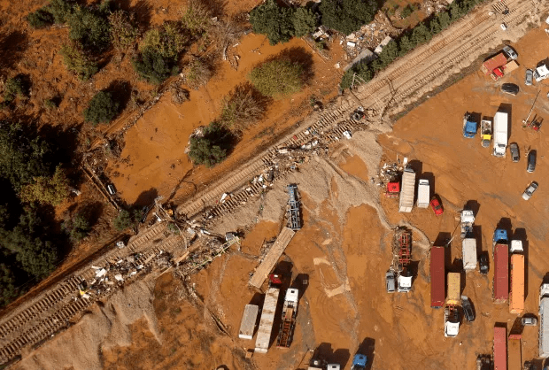 an aerial view of a flooded area with train tracks and trucks