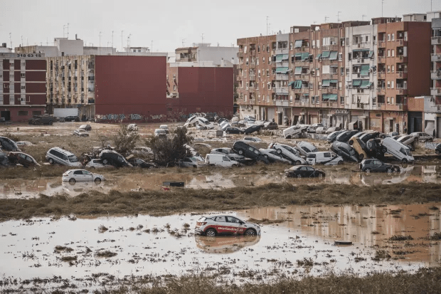 a flooded parking lot with a red car in the middle