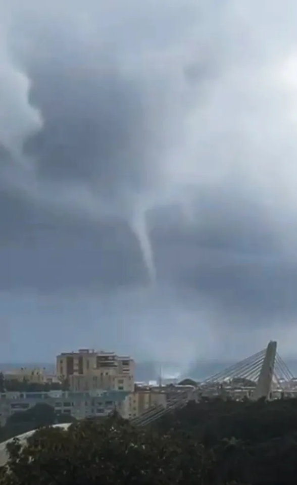 a tornado is moving through a cloudy sky over a city