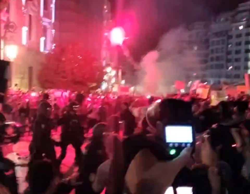 Riots cops battled against furious protesters with one angry local launching a flare at a government building