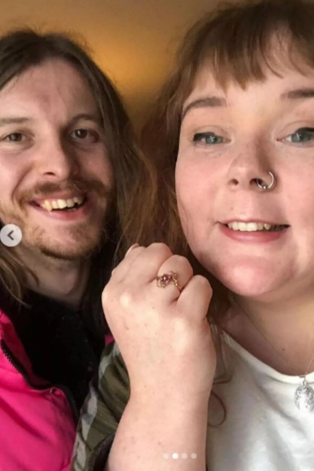 a man and a woman are posing for a picture and the woman has a ring on her finger