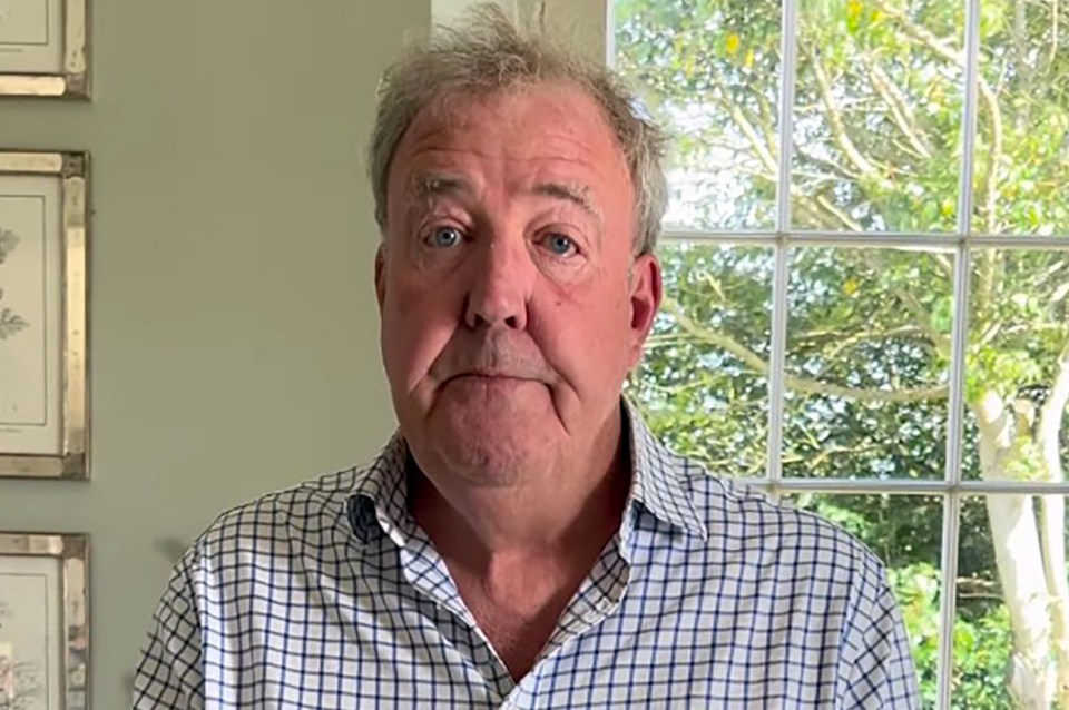 a man in a plaid shirt stands in front of a window