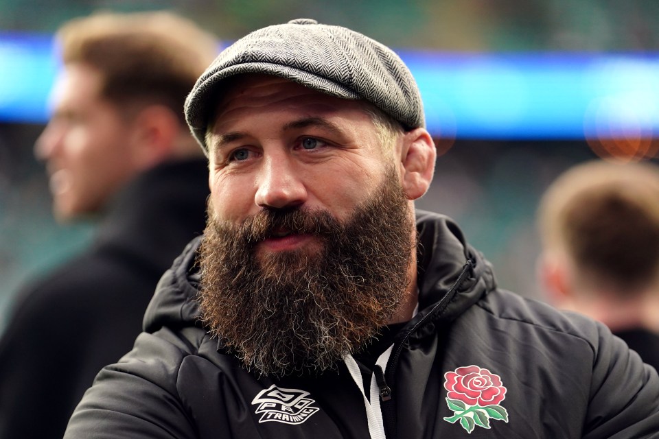 a man with a beard is wearing a jacket with a rose on it